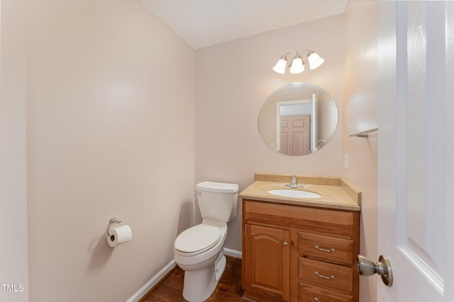 bathroom with vanity, toilet, and a textured ceiling