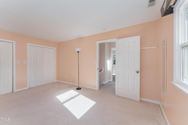 unfurnished bedroom featuring multiple windows and light colored carpet