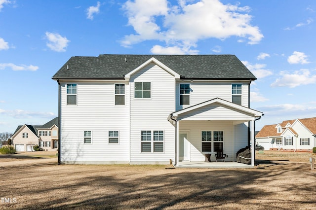 rear view of property featuring a lawn and a patio