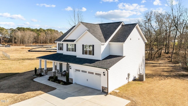 view of front of house with a porch, a garage, and central air condition unit