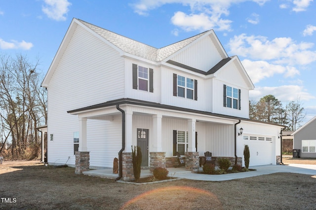 view of front facade featuring a garage, a front lawn, and covered porch