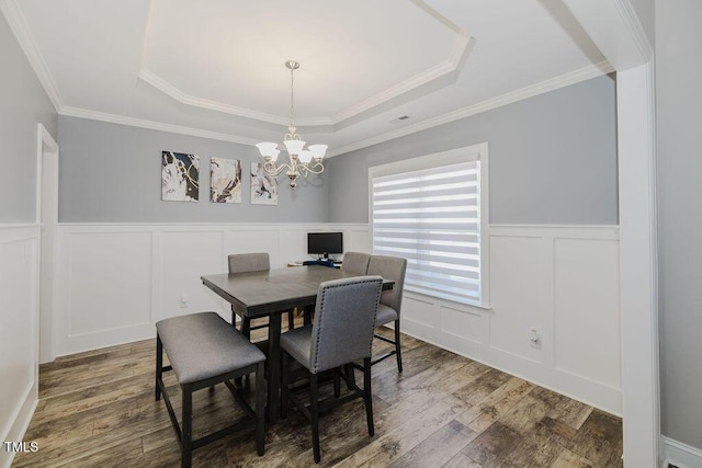 dining space featuring crown molding, a chandelier, dark hardwood / wood-style flooring, and a tray ceiling