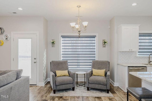 sitting room with sink, a notable chandelier, and light hardwood / wood-style floors