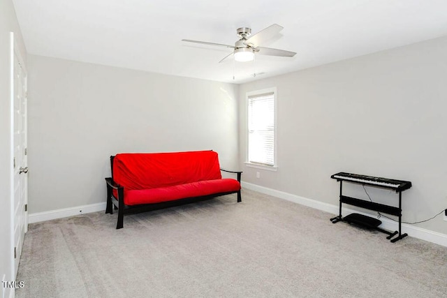 living area with light carpet and ceiling fan