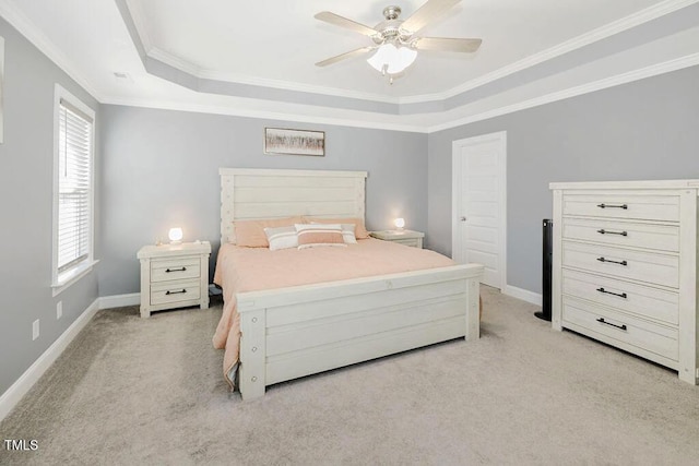 bedroom featuring crown molding, light carpet, ceiling fan, and a tray ceiling