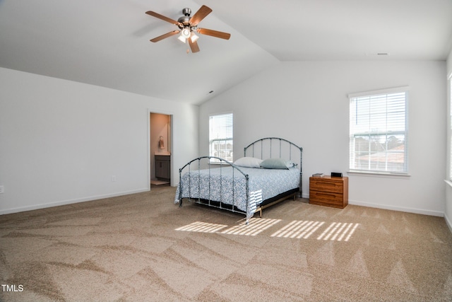 carpeted bedroom featuring ceiling fan, lofted ceiling, connected bathroom, and multiple windows