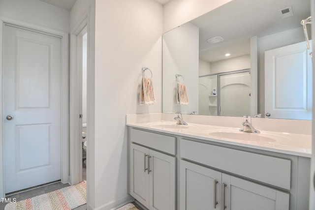 bathroom featuring tile patterned flooring, vanity, and walk in shower