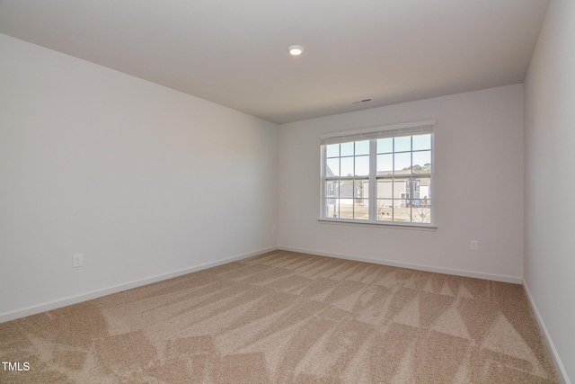 unfurnished room featuring light carpet