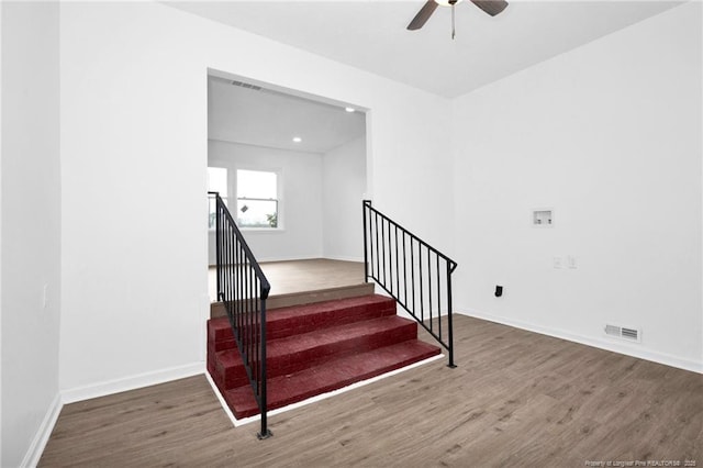 stairs with ceiling fan and hardwood / wood-style flooring