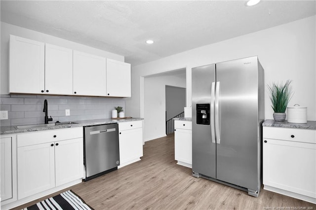 kitchen featuring decorative backsplash, sink, white cabinets, and stainless steel appliances