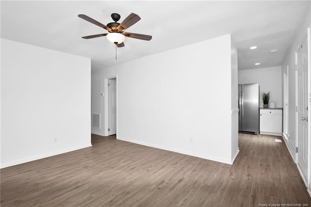 spare room featuring ceiling fan and dark wood-type flooring