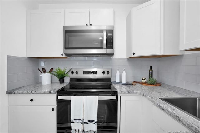 kitchen featuring white cabinets, stainless steel appliances, and tasteful backsplash