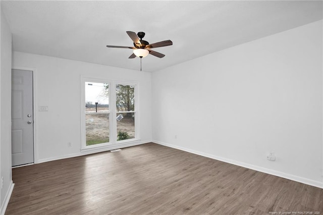 empty room featuring ceiling fan and dark wood-type flooring