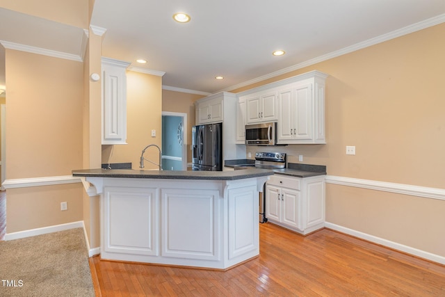 kitchen featuring stainless steel appliances, white cabinets, light wood-type flooring, kitchen peninsula, and crown molding