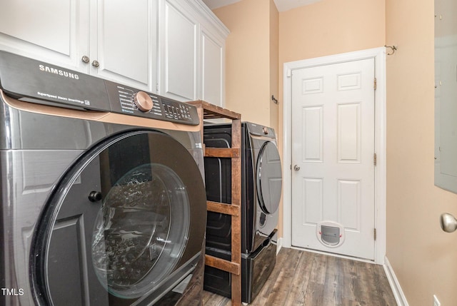 laundry area with independent washer and dryer, dark wood-type flooring, and cabinets