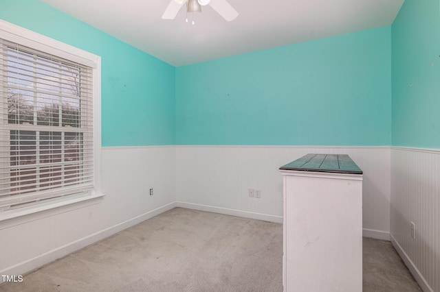 empty room featuring ceiling fan and light carpet