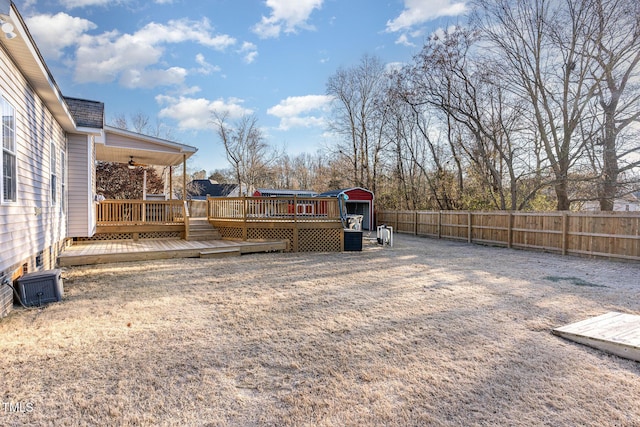 view of yard with central air condition unit, ceiling fan, and a wooden deck