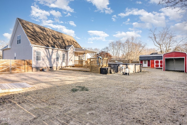 rear view of house with an outdoor structure and a swimming pool side deck