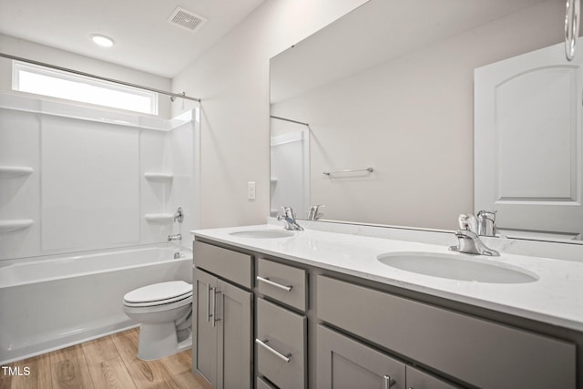 full bathroom with vanity, wood-type flooring,  shower combination, and toilet