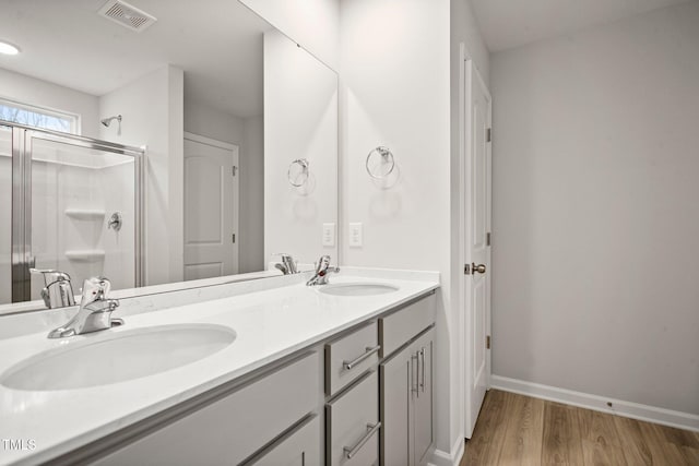 bathroom with hardwood / wood-style floors, vanity, and walk in shower