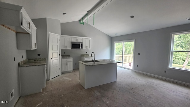 121 Tanglewood Dr Unit 8-J, Louisburg, NC 27549 - kitchen featuring stainless steel microwave, a sink, a kitchen island with sink, white cabinetry, and baseboards