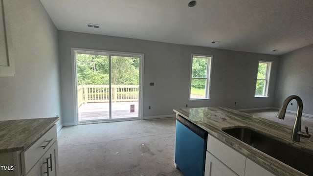 121 Tanglewood Dr Unit 8-J, Louisburg, NC 27549 - kitchen with dishwashing machine, a sink, white cabinetry, stone counters, and baseboards