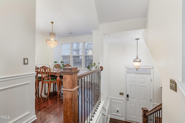 interior space featuring a chandelier, ornamental molding, and dark wood-type flooring