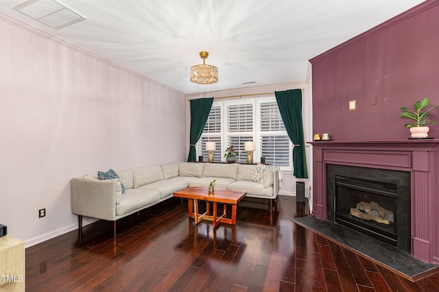 living room with crown molding, a chandelier, and dark hardwood / wood-style floors