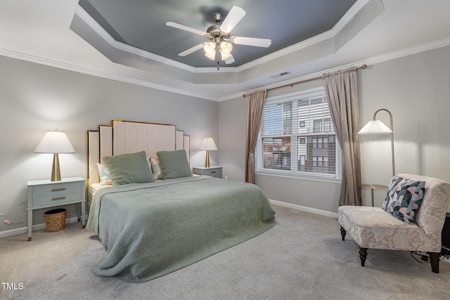 carpeted bedroom featuring a tray ceiling, ceiling fan, and crown molding