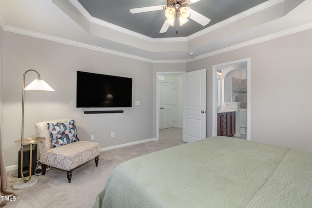 carpeted bedroom featuring connected bathroom, a tray ceiling, ceiling fan, and crown molding