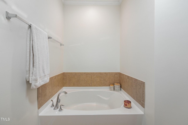 bathroom with crown molding and a bathtub