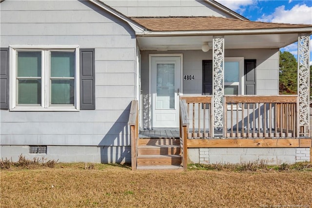 doorway to property with a lawn and a porch