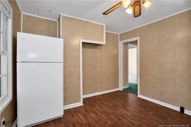 interior space with ornamental molding, white refrigerator, ceiling fan, and dark wood-type flooring