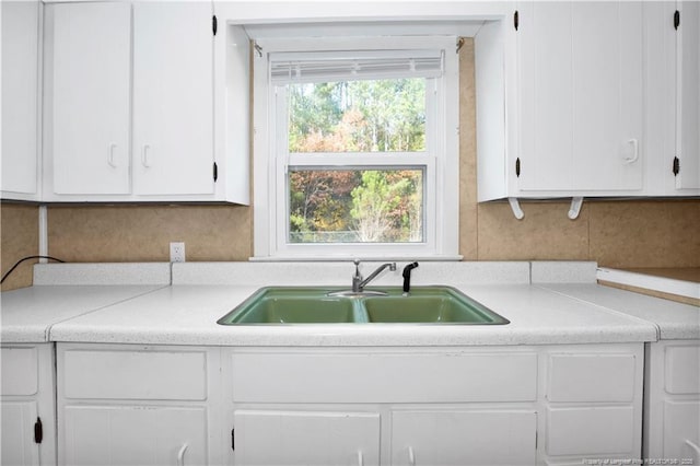 kitchen featuring white cabinets and sink