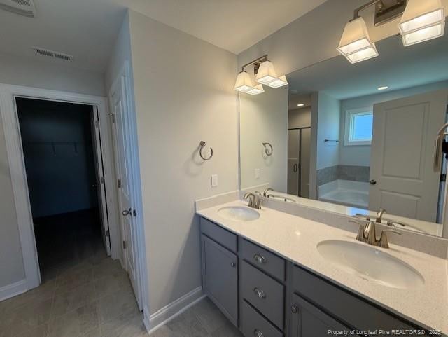 bathroom with baseboards, visible vents, and a sink