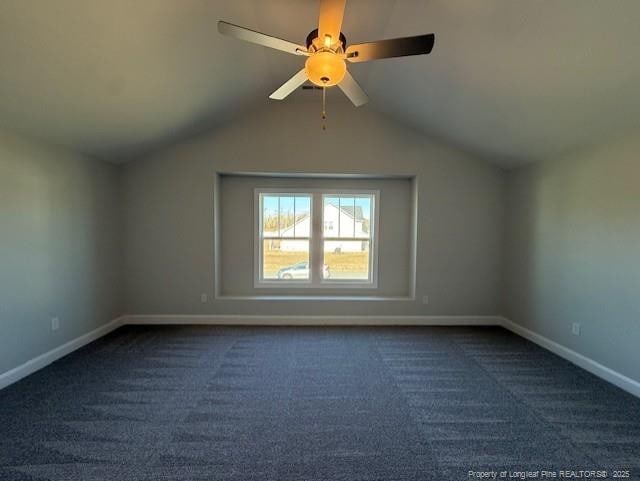 additional living space featuring lofted ceiling, baseboards, and dark colored carpet