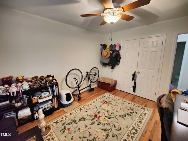 bedroom with a closet, hardwood / wood-style flooring, and ceiling fan