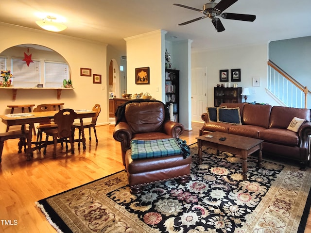 living room with crown molding, ceiling fan, and wood-type flooring