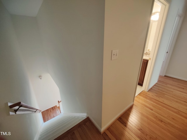 corridor with light wood finished floors and baseboards