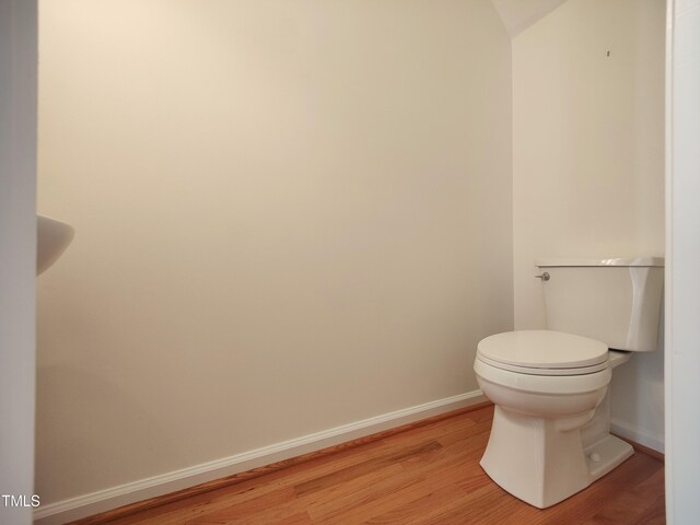 bathroom featuring wood finished floors, toilet, and baseboards