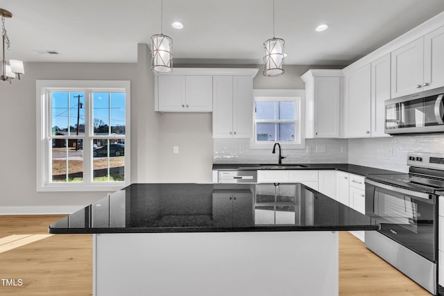 kitchen featuring decorative light fixtures, a center island, and appliances with stainless steel finishes