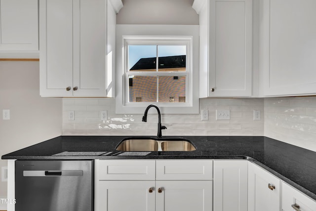 kitchen with dark stone counters, sink, stainless steel dishwasher, tasteful backsplash, and white cabinetry