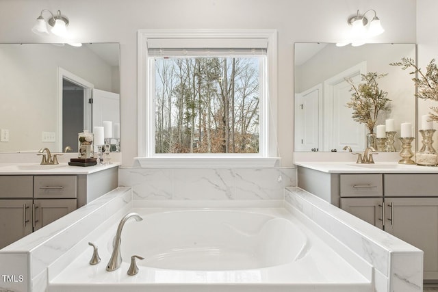 bathroom with vanity, plenty of natural light, and a tub to relax in