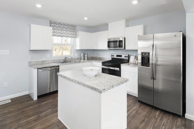 kitchen with a center island, dark wood-type flooring, sink, white cabinetry, and stainless steel appliances