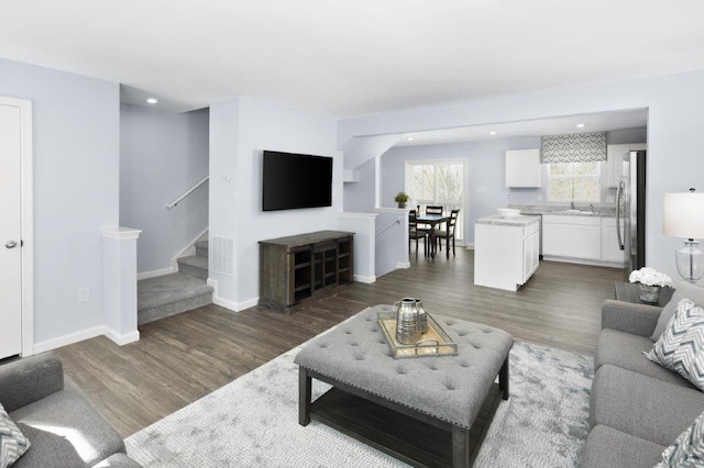 living room featuring dark hardwood / wood-style flooring and sink