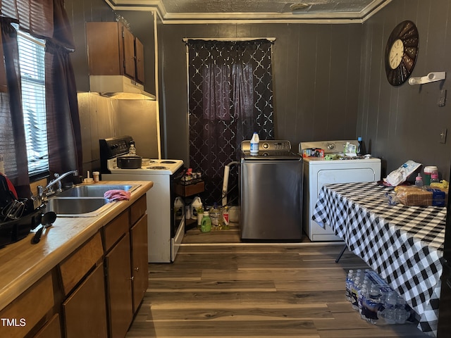 kitchen with wooden walls, dark wood-type flooring, crown molding, sink, and electric range