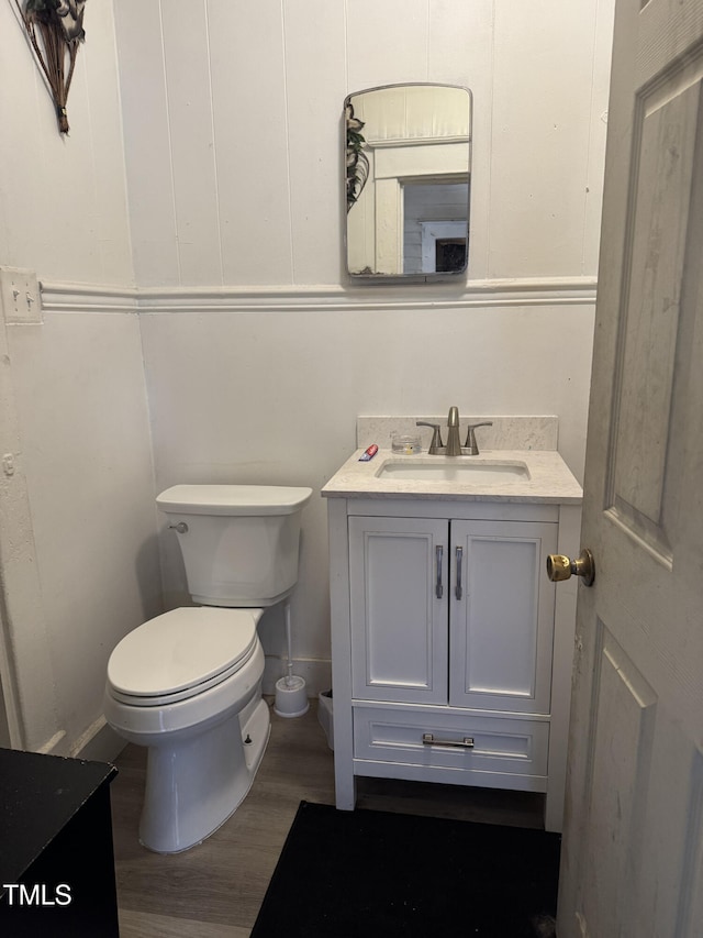 bathroom featuring vanity, wood-type flooring, and toilet