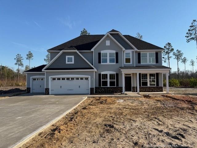 craftsman house with an attached garage, covered porch, and concrete driveway