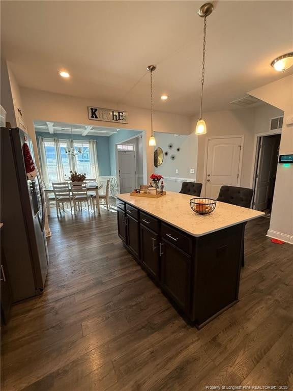 kitchen with a kitchen island, dark wood-type flooring, decorative light fixtures, freestanding refrigerator, and recessed lighting