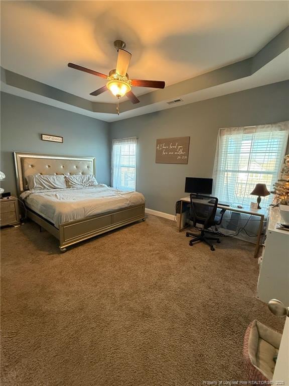 bedroom with ceiling fan, carpet, baseboards, and a raised ceiling